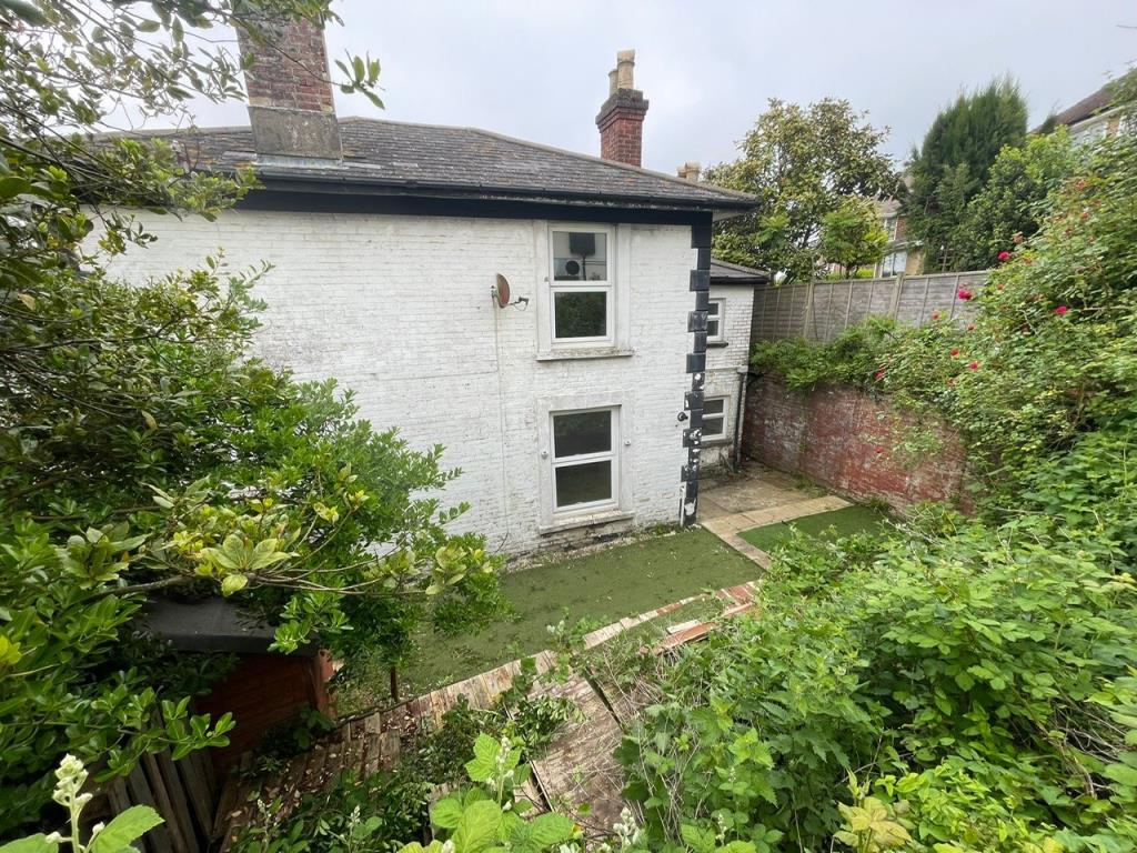 Lot: 11 - THREE-BEDROOM HOUSE FOR IMPROVEMENT - Courtyard garden with side elevation and view of roof